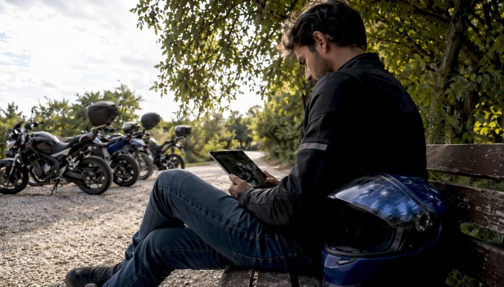 Un uomo consulta l'app per il noleggio di moto mentre è all'aperto.